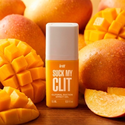 Frasco de gel amarelo com tampa branca rodeado por mangas frescas cortadas e inteiras.
