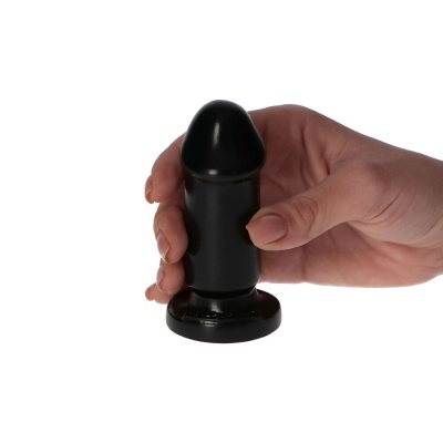 Produto cilíndrico preto de silicone com base larga segurado por uma mão