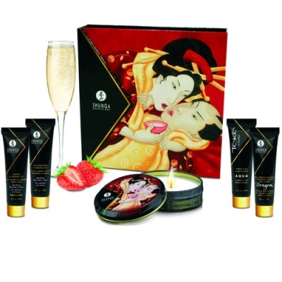 conjunto de produtos Shunga Erotic Art com embalagem japonesa, tubos pretos dourados, vela em lata, morangos e taça de bebida