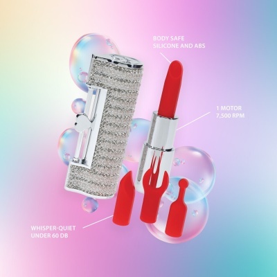 Vibrador em forma de baton com acessórios vermelhos e estojo decorado.