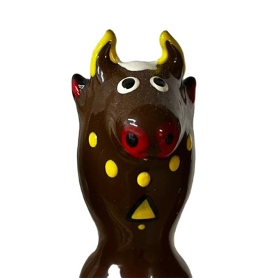 Figura decorativa de animal estilizado castanho com detalhes vermelhos e amarelos