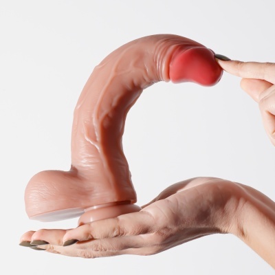 Objeto de silicone cor de pele e vermelho em mão com unhas verdes