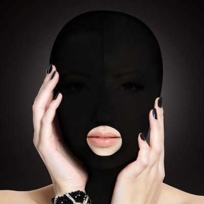 Máscara facial preta com abertura na boca e mãos femininas segurando-a