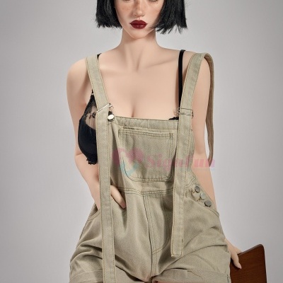 Boneca realista com cabelo preto, roupa de ganga e soutiens pretos sentada numa cadeira