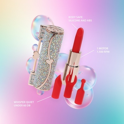 Dispositivo semelhante a batom prateado com strass e acessórios vermelhos em fundo colorido