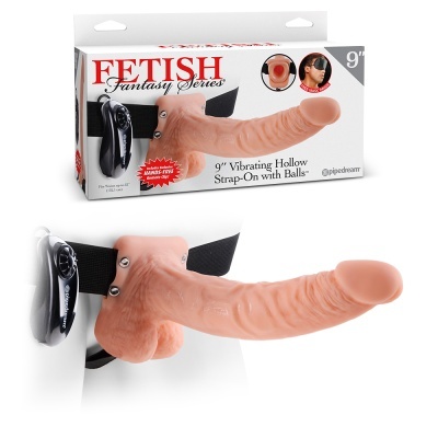 Imagem de um strap-on vibratório cor de pele com correia preta e controle remoto, ao lado da embalagem do produto.