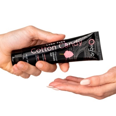 Tubinho preto de gel íntimo sabor algodão doce segurado por mãos femininas