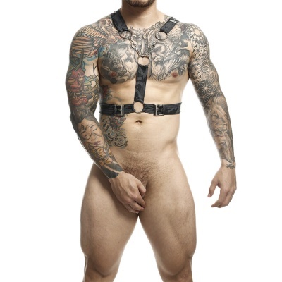 Homem com arnês de couro preto e tatuagens no corpo, fundo branco