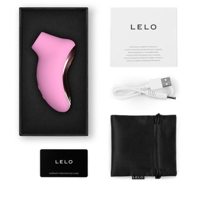 Produto rosa com detalhes metálicos em caixa preta com acessórios e manual