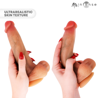 Dois vibradores realistas castanhos com textura de pele ultrarrealista segurados por mãos femininas com unhas vermelhas