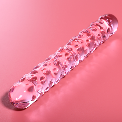 Dildo de vidro rosa com textura, sobre fundo rosa.