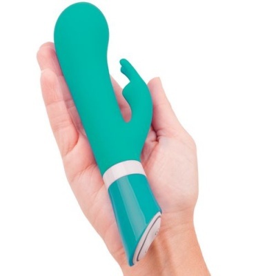 Vibrador verde de silicone com controlo azul numa mão