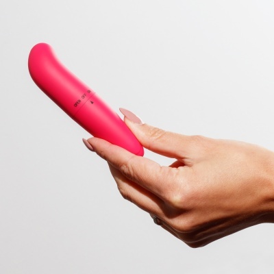 Produto cilíndrico cor de rosa segurado por uma mão
