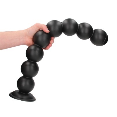 Objeto preto em forma de esferas conectadas com ventosa sendo segurado por uma mão.