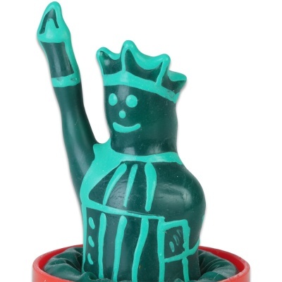 Figura de borracha verde com coroa e braço levantado no interior de recipiente vermelho