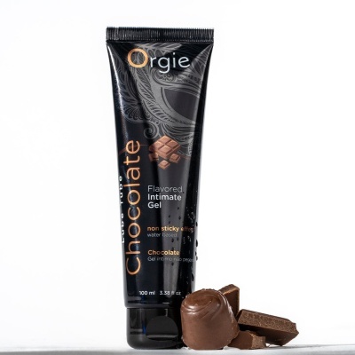 Tubo preto de gel íntimo de chocolate Orgie com pedaços de chocolate ao lado.