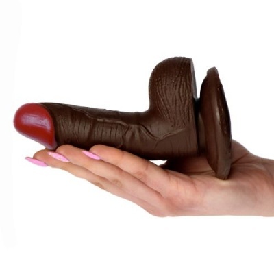 Dildo castanho escuro com ponta vermelha e base de ventosa na mão