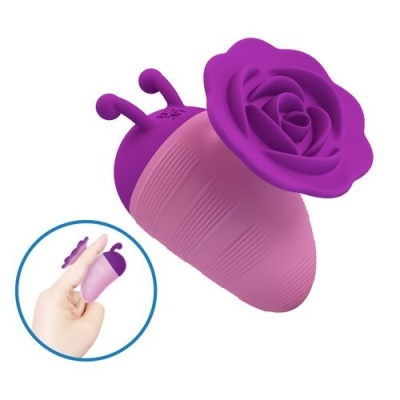 Produto rosa e roxo com textura e flor roxa em cima, mostrado segurado entre dedos.