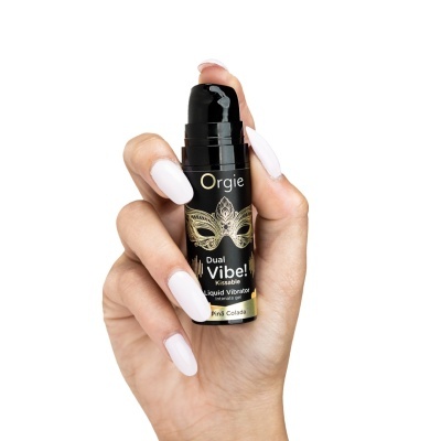 Frasco preto de gel íntimo vibrador líquido com texto e decoração dourada, segurado por mão com unhas brancas