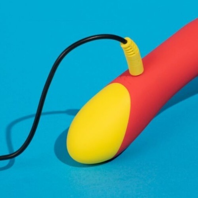 Dispositivo vermelho e amarelo com cabo preto ligado sobre fundo azul