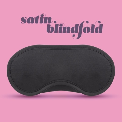 Máscara de dormir preta com texto satin blindfold roxo em fundo cor-de-rosa