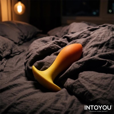 Plug anal amarelo e laranja em tecido preto