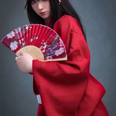 Boneca com quimono vermelho e leque com padrão floral