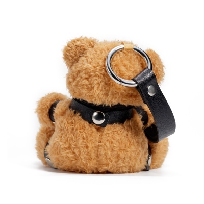 Mochila de peluche castanha clara com tiras e argolas metálicas.