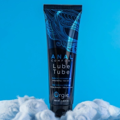Gel íntimo híbrido Anal Comfort Lube Tube Orgie em tubo preto e azul com algodão e fundo azul.
