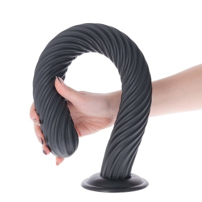 Produto de silicone preto com textura ondulada e base de ventosa, segurado por uma mão