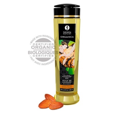 Frasco amarelo translúcido de óleo de massagem com rótulo artístico e tampa preta, acompanhado de amêndoas.