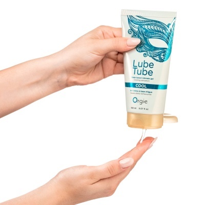 Tubo de gel íntimo Lube Tube Orgie com desenho azul e tampa castanha, a ser aplicado por uma mão