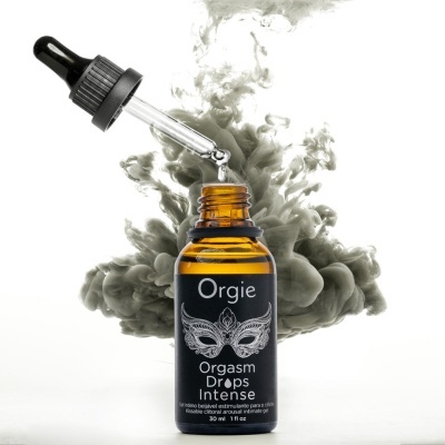 Frasco âmbar com conta-gotas e rótulo preto de Orgie Orgasm Drops Intense, fundo de fumaça cinza.