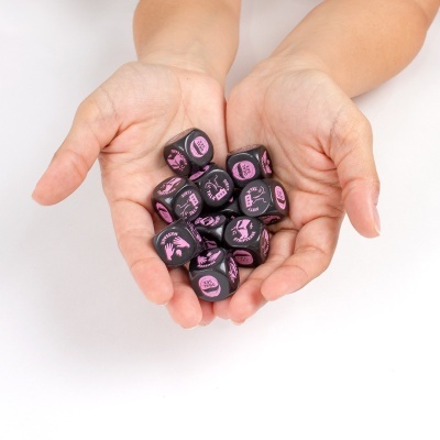 Mãos segurando dados pretos com textos e ícones cor de rosa