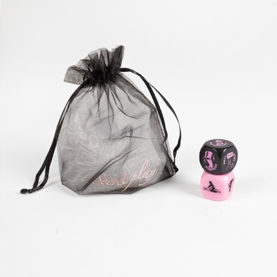 Dados preto e rosa com ilustrações e texto, e bolsa de organza preta com texto Secret play