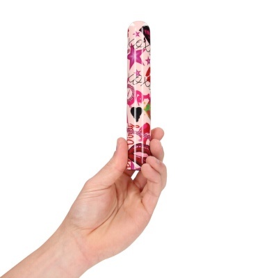Vibrador cilíndrico colorido com padrão decorativo segurado por mão