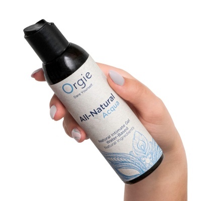 Frasco preto de gel íntimo natural à base de água segurado por mão com unhas brancas cinzentas