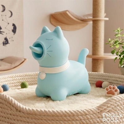 Figura de gato azul claro com gola branca em cesta trançada com almofada e bolas coloridas