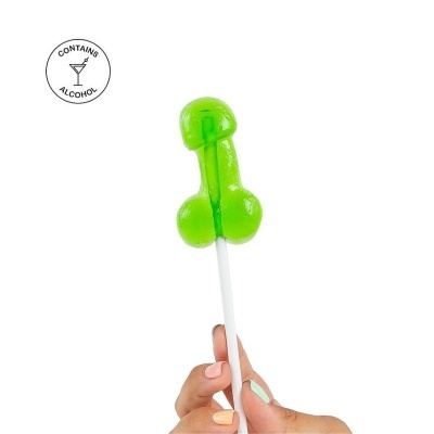 Pirulito verde em forma de pênis segurado por duas mãos com unhas pintadas, texto CONTAINS ALCOHOL no canto