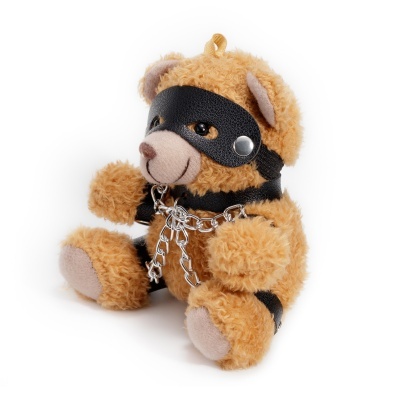 Urso de peluche castanho claro com máscara e acessórios pretos e corrente prateada