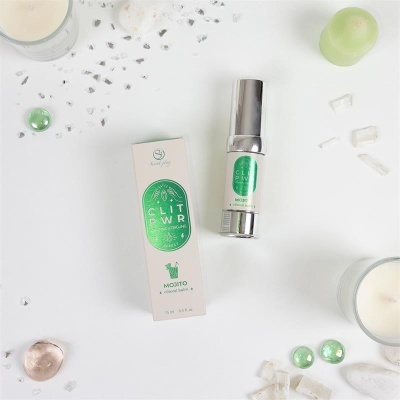 Frasco e caixa de bálsamo clitoral Mojito em fundo branco com pedras e velas