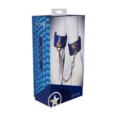 Caixa azul com padrão texturizado contendo algemas para pernas azuis com correntes douradas