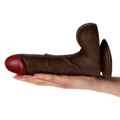 Objeto castanho com ponta vermelha na mão de mulher com unhas rosa