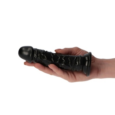 Mão segurando um dildo preto texturizado com ventosa na base