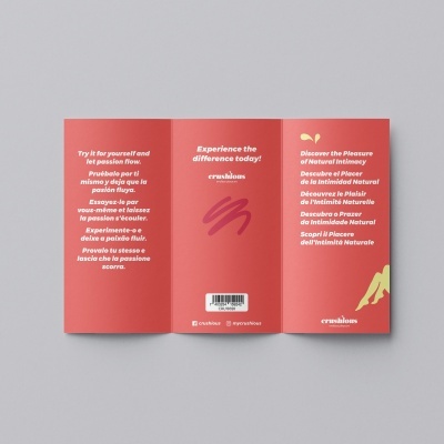 Folheto vermelho dobrado com texto multilingue e código de barras sobre superfície cinzenta