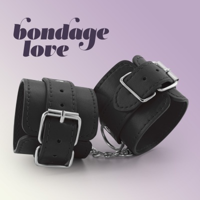 Conjunto de algemas em pele preta com fivelas metálicas prateadas e correntes com texto bondage love ao fundo
