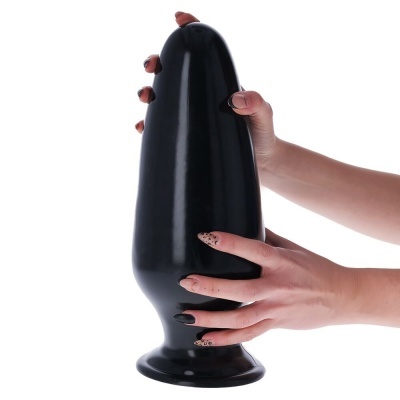 Produto preto liso grande com base segurado por mãos femininas com unhas decoradas