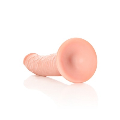 Dildo cor pele com ventosa na base sobre fundo branco