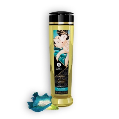 Frasco de óleo para massagem erótica com rótulo ilustrado e flor azul ao lado