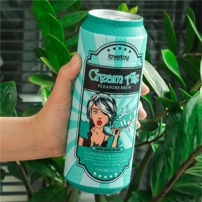 Lata azul e branca de bebida Cream Ale com design gráfico estilizado em ambiente com plantas